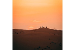 Image People at sunset in desert sitting in dunes